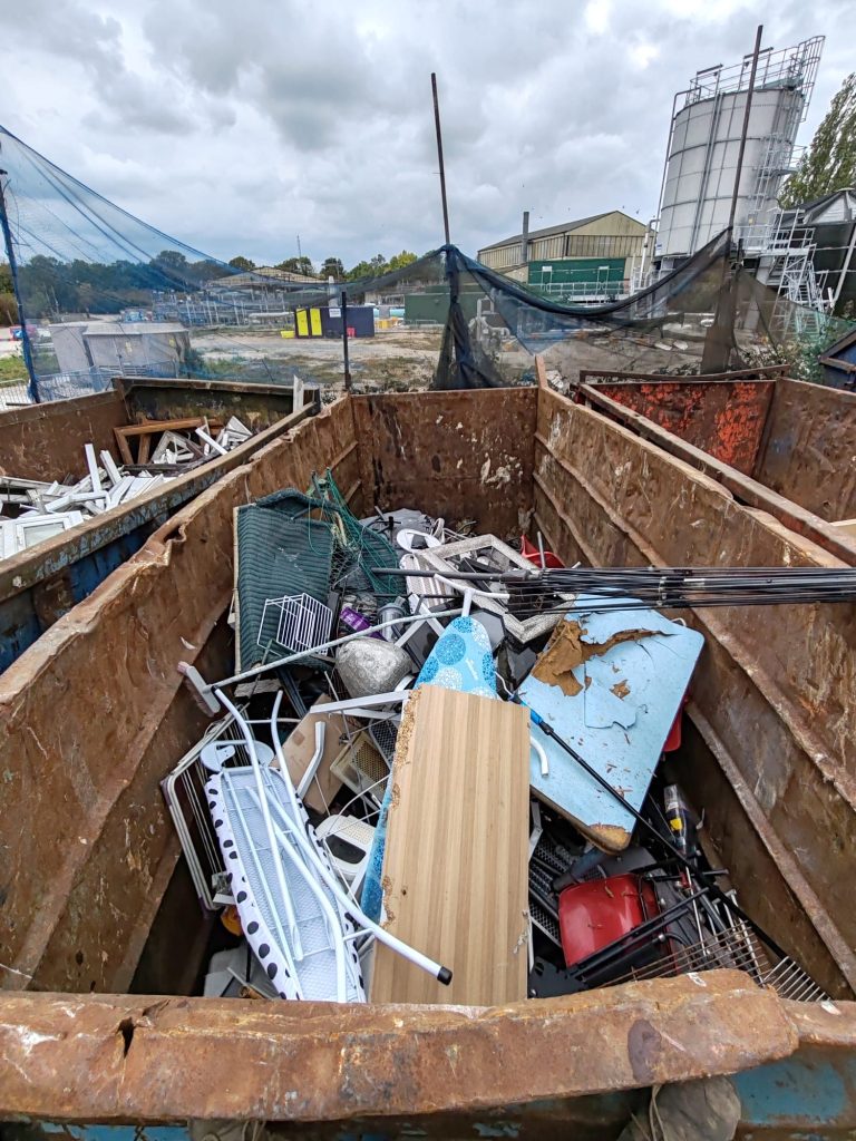 A picture of a 40 yard bin containing scrap metal like ironing boards and desks