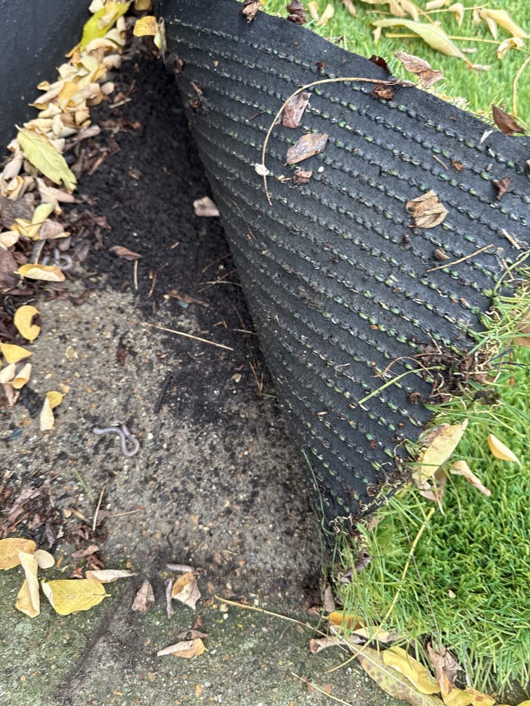 A picture of the underside of some artificial grass, showing the stitching.